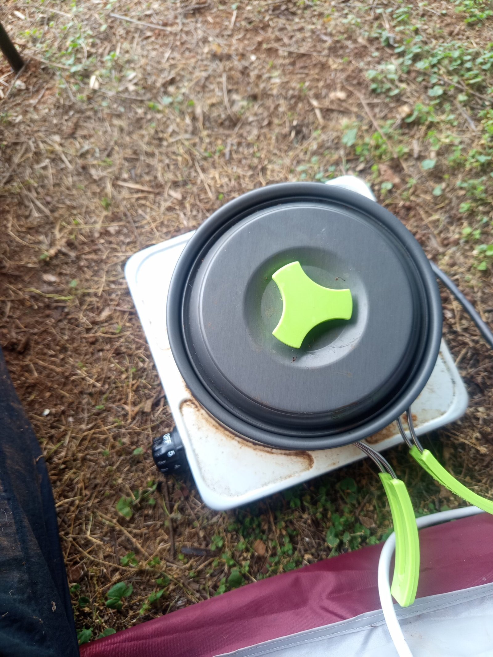 Geschlossener Campingtopf mit Deckel während des Backversuchs auf einer elektrischen Kochplatte